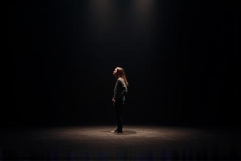 Student practicing a monologue on stage.
