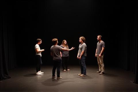 Students rehearsing a scene on a small studio stage.